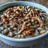Southern-style Crock-Pot Black-Eyed Peas with Smoked Turkey alongside fluffy white rice and golden cornbread slices.