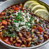 The dish features tender legumes and diced carrots in a rich, aromatic tomato broth.