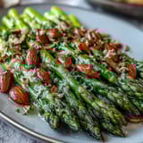 Elegant asparagus sautéed in citrusy butter, topped with golden almonds, makes a bright vegetarian side for festive meals.  