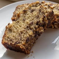 A freshly baked banana bread loaf with a golden crust and inviting aroma.